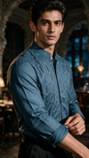 A man wearing a bottle green long-sleeve button-up shirt with a subtle grid pattern of small cross stitch. 